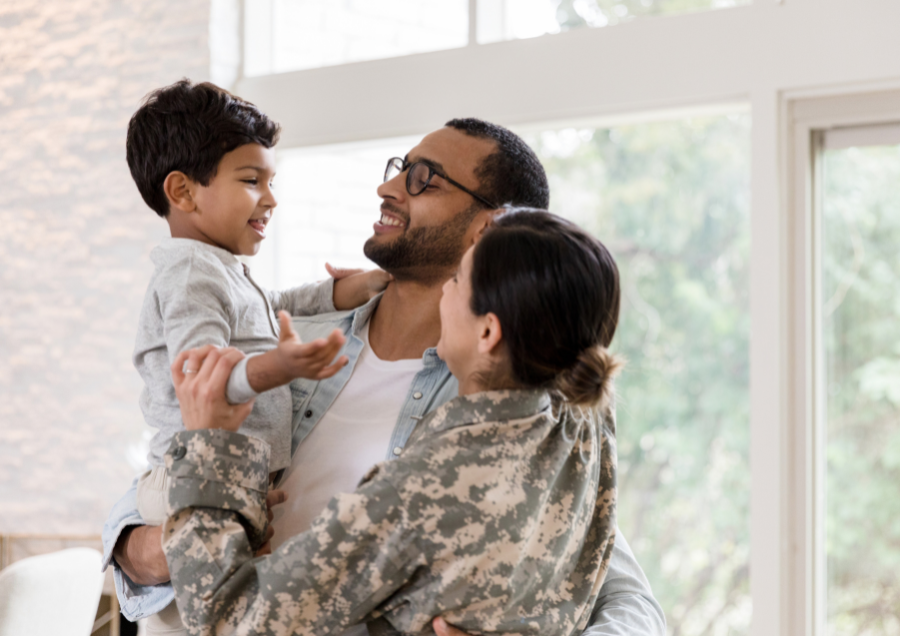 Famille réunie dans une maison, le père porte l’enfant et la mère les accueille, symbolisant un déménagement clé en main et sans souci.