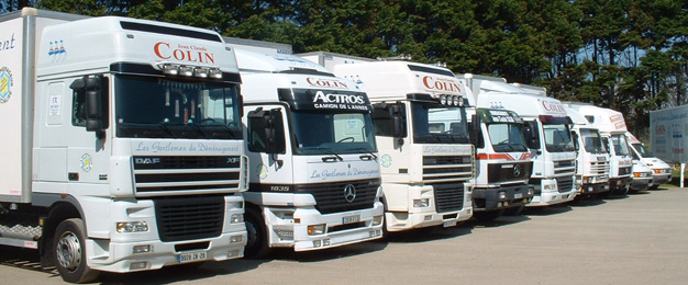 Une ligne de camions de déménagement blancs prêt à partir, alignés sur le parking.