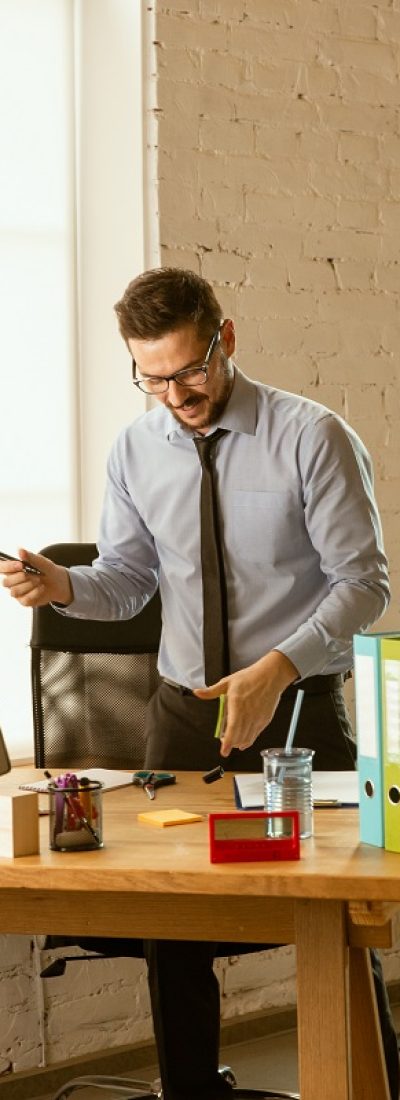 Management. A young businessman moving in the office, getting new work place. Young male office worker while managing after promotion. Looks happy. Business, lifestyle, new life concept. Unpacking.